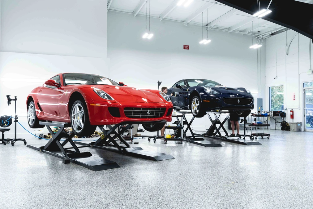 Two Ferraris on lifts inside the Detailers of Fort Myers climate-controlled bay
