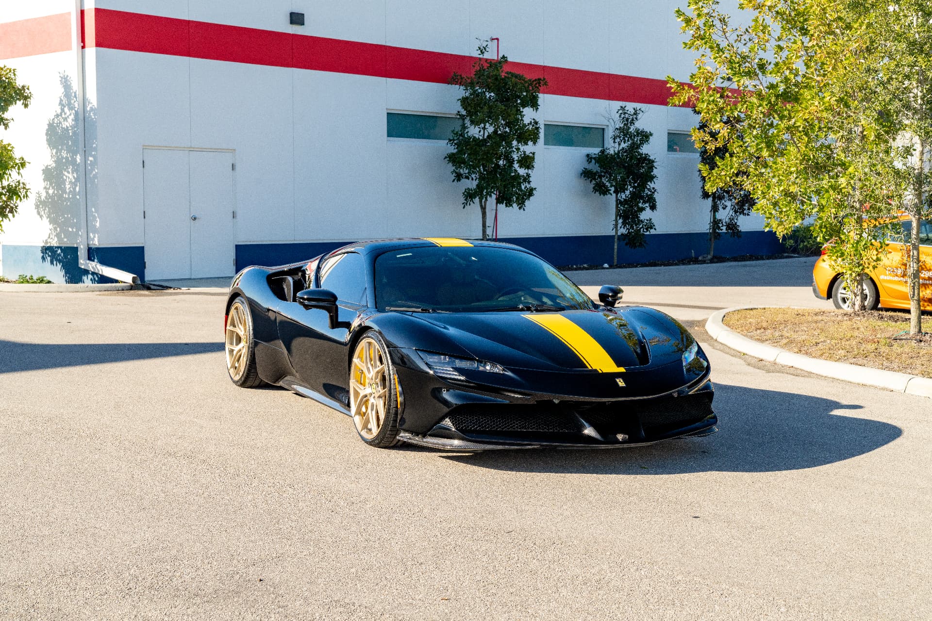 Black Ferrari SF90 with yellow stripe finished with ceramic coating and film
