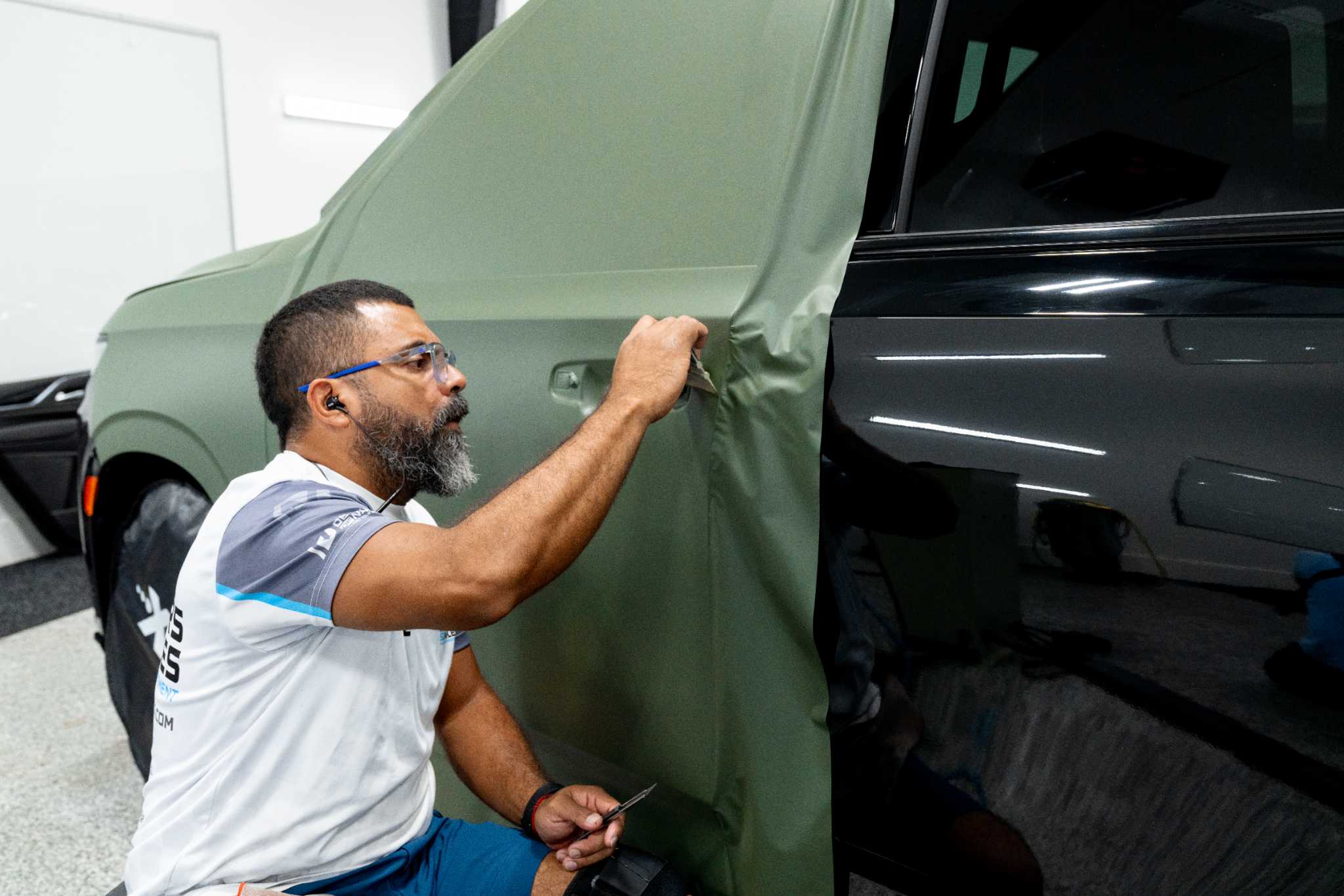 Technician applying paint protection film with a squeegee